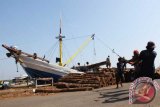 Pekerja melakukan bongkar muatan kayu gelondongan dari atas geladak kapal tradisional di Pelabuhan Mayangan, Pasuruan, Jawa Timur, Jumat (25/2). Sejak dicanangkan pada 1 Januari 2016, pemberlakukan sertifikat verifikasi legalitas kayu (SVLK) untuk semua produk perkayuan di tanah air belum optimal karena ketidaksiapan mayoritas pelaku usaha kecil dan menengah. Antara Jatim/Destyan Sujarwoko/zk/16