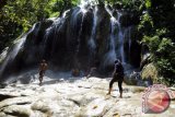 Pengunjung mandi dan beraktifitas di Air Terjun Pelang yang berada di Desa Wonocoyo Kecamatan Panggung, Trenggaek, Jawa Timur, Jum'at (25/3). Air terjun yang oleh warga sekitar juga di sebut air terjun gerobogan sewu tersebut memiliki ketinggian 25 meter dan menjadi salah satu potensi wisata baru di kawasan selatan Jawa Timur. Antara Jatim/Irfan Anshori/zk/16