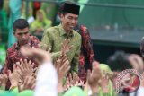 Presiden Joko Widodo menyalami peserta dalam Harlah Muslimat NU Ke-70 di Stadion Gajayana, Malang, Jawa Timur, Sabtu (26/3). Harlah tersebut diikuti sekitar 50 ribu peserta. Antara Jatim/Ari Bowo Sucipto/zk/16.