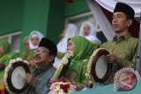 Presiden Joko Widodo (kanan) menabuh rebana bersama Ketua PP Muslimat NU, Khofifah Indar Parawansa (tengah) dan Gubernur Jatim, Sukarwo (kiri) dalam Harlah Muslimat NU Ke-70 di Stadion Gajayana, Malang, Jawa Timur, Sabtu (26/3). Harlah tersebut diikuti sekitar 50 ribu peserta. Antara Jatim/Ari Bowo Sucipto/zk/16.