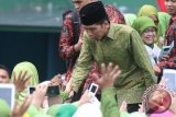 Presiden Joko Widodo menyalami peserta dalam Harlah Muslimat NU Ke-70 di Stadion Gajayana, Malang, Jawa Timur, Sabtu (26/3). Harlah tersebut diikuti sekitar 50 ribu peserta. Antara Jatim/Ari Bowo Sucipto/zk/16.