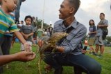 Penggemar reptil bermain dengan seekor biawak saat pertemuan pecinta reptil di Alun-alun Kota Madiun, Jawa Timur, Sabtu (26/3). Acara yang diadakan Komunitas Reptil Madiun (Korem) tersebut menjadi ajang bertukar wawasan tentang reptil dan mengajak masyarakat agar mencintai reptil. (Foro Siswowidodo/aww)