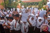 Sejumlah siswa SDN 4 Sukasari menunjukkan surat yang ditujukkan untuk Presiden Indonesia Joko Widodo, Tangerang, Banten, Selasa (29/3). Dalam suratnya mereka menulis permintaan untuk direlokasi karena gedung sekolahnya akan digusur, sementara pembangunan gedung baru sekolah mereka dihentikan oleh Kementerian Hukum dan Ham (Kemenkumham). ANTARA FOTO/Lucky R./wdy/16.