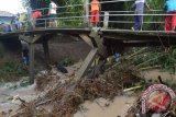 Sejumlah warga membersihkan rumpun bambu dan sampah di sekitar tiang jembatan yang ambruk di Tempursari, Kota Madiun, Jawa Timur, Kamis (31/3). Hujan deras menyebabkan banjir dan merobohkan sejumlah rumpun bambu dan terseret arus air deras merobohkan tiang jembatan tersebut. Antara Jatim/Foto/Siswowidodo/zk/16