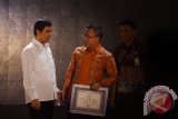 Menpan RB Yuddy Chrisnandi (kiri) berbincang dengan Bupati Banyuwangi Abdullah Azwar Anas (tengah) saat penyerahan piagam penghargaan dalam acara Simposium dan Gelar Inovasi Pelayanan Publik Nasional 2016 di Surabaya, Jawa Timur, Kamis (31/3). Kegiatan yang berlangsung hingga 2 April 2016 tersebut bertujuan untuk mempromosikan inovasi pelayanan publik dari segenap unit penyelenggara di setiap kementerian, lembaga, pemerintah provinsi, pemerintah kota dan kabupaten, serta BUMN dan BUMD. Antara Jatim/Zabur Karuru/16