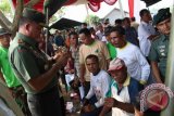 Pangdam I/Bukit Barisan Mayjen TNI Lodewyk Pusung (kiri) memperlihatkan padi hasil bibit benih kartika I/82 bersama petani saat panen raya di kawasan persawahan Sei Bingei Kabupaten Langkat, Sumatera Utara, Kamis (31/3). Jajaran Kodam I/BB membantu masyarakat setempat dalam mencapai swasembada pangan dengan menyuplai bibit benih kartika I/82 serta menambahkan pendamping atau penyuluh bagi kelompok tani untuk dapat meningkatkan produksi padi nasional. ANTARA SUMUT/Septianda Perdana/16