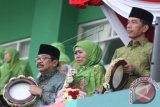 Presiden Joko Widodo (kanan) menabuh rebana bersama Ketua PP Muslimat NU Khofifah Indar Parawansa (tengah) dan Gubernur Jatim Sukarwo (kiri) saat acara Harlah Muslimat NU ke-70 di Stadion Gajayana, Malang, Jawa Timur, Sabtu (26/3). Harlah tersebut diikuti sekitar 50 ribu peserta. ANTARA FOTO/Ari Bowo Sucipto/wdy/16.
