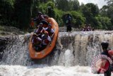 Sejumlah wisatawan menaiki perahu karet saat melakukan wisata petualangan arung jeram di sungai Badeng, Songgon, Banyuwangi, Jawa Timur, Minggu (3/4). Pemerintah Kabupaten Banyuwangi terus mengembangkan sektor pariwisata dengan konsep Sport Tourism seperti Arung jeram, selancar, dan balab sepeda yang banyak diminati oleh wisatawan lokal maupun mancanegara. Antara Jatim/ Budi Candra Setya/zk/16.