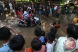 Warga memancing ikan di jalan rusak yang tergenang air hujan di Desa Kaloran, Nganjuk, Jawa Timur, Minggu (3/4). Warga sengaja menebar ikan Lele dan memancing beramai-ramai di jalan tersebut sebagai wujut protes kepada pemerintah daerah setempat yang tak kunjung memperbaiki jalan utama desa mereka. Antara Jatim/Prasetia Fauzani/zk/16