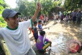 Warga memancing ikan di jalan rusak yang tergenang air hujan di Desa Kaloran, Nganjuk, Jawa Timur, Minggu (3/4). Warga sengaja menebar ikan Lele dan memancing beramai-ramai di jalan tersebut sebagai wujut protes kepada pemerintah daerah setempat yang tak kunjung memperbaiki jalan utama desa mereka. Antara Jatim/Prasetia Fauzani/zk/16