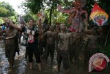 Sejumlah seniman dari sanggar Sastrajendra melakukan pertunjukan Teater di jalan yang banjir oleh air hujan di Desa Kaloran, Nganjuk, Jawa Timur, Minggu (3/4). Pertunjukan berjudul 'Baju Licin' tersebut merupakan kritik sosial terhadap pemimpin korup yang tidak memperdulikan penderitaan rakyat kecil. Antara Jatim/Prasetia Fauzani/zk/16