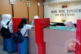 Kediri (Antara Jatim) - Sejumlah pelajar menyetorkan uang pembayaran sekolah ke bank yang didirikan di lingkungan sekolah di SMK PGRI II Kota Kediri, Jawa Timur, Senin (4/4). Bank ini sengaja didirikan. Seluruh kegiatan transaksi baik tabungan maupun pembayaran dilakukan di bank sekolah ini. Selain sebagai pelatihan untuk siswa di jurusan akuntansi, juga untuk melatih siswa agar berminat untuk menabung. Antara Jatim/Foto/Asmaul Chusna 