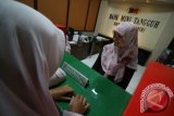 Siswa melakukan transaksi di Bank Sekolah di salah satu Sekolah Menengah Kejuruan (SMK) swasta  di Kota Kediri, Jawa Timur, Senin (4/4). Repelika Bank dengan nasabah khusus siswa, guru, dan petugas  di lingkungan sekolah tersebut dapat memberikan pelayanan layaknya bank pada umumnya yakni menabung, hutang, bayar SPP, ambil gaji guru dan lain sebagainya guna memberikan kemudahan transaksi keuangan sekaligus sebagai laboratorium pendidikan bagi siswa jurusan Akuntansi. Antara Jatim/Prasetia Fauzani/zk/16