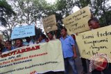 Para sopir taksi Bandara Kualanamu melakukan aksi unjukrasa dengan membentangkan poster di depan gedung DPRD Sumut Medan, Sumatera Utara, Senin (4/4). Para sopir taksi tersebut menuntut pemerintah setempat untuk segera menertibkan keberadaan taksi bernomor polisi plat hitam yang melayani penumpang secara ilegal di kawasan Bandara Internasional Kualanamu. ANTARA SUMUT/Septianda Perdana/16