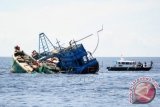 Kapal Polisi Air (Polair) berada di samping dua kapal motor nelayan Vietnam yang ditenggelamkan di Pulau Datuk, Kabupaten Mempawah, Kalbar, Selasa (5/4). Kementerian Kelautan dan Perikanan bersama Polri menenggelamkan dua kapal Vietnam yaitu KM Sinar-288/BV3240TS dan KM Sinar-533/BV99253TS yang ditangkap Kapal Patroli Pinguin-5011 dari Ditpolair Mabes Polri saat sedang mencuri ikan di Perairan Pulau Sumpadi, Kabupaten Sambas, Kalbar pada Maret lalu. ANTARA FOTO/Jessica Helena Wuysang/wdy/16.