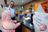 Kepala Imigrasi Blitar Tato Juliadin Hidayawan berbicang dengan seorang Calon Jamaah Haji (CJH) asal Kabupaten Trenggalek di Kantor Imigrasi Klas II Blitar, Jawa Timur, Rabu (6/4). Untuk mempermudah pelayanan permohonan paspor bagi 1.979 CJH asal Kabupaten/Kota Blitar, Tulungagung, dan Trenggalek, mulai hari ini Kantor Imigrasi Blitar menerapkan dua shift waktu pelayanan khusus bagi CJH yakni pagi dan siang. Antara Jatim/Irfan Anshori/k/16