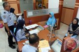 Kepala Imigrasi Blitar Tato Juliadin Hidayawan berbicang dengan seorang Calon Jamaah Haji (CJH) asal Kabupaten Trenggalek di Kantor Imigrasi Klas II Blitar, Jawa Timur, Rabu (6/4). Untuk mempermudah pelayanan permohonan paspor bagi 1.979 CJH asal Kabupaten/Kota Blitar, Tulungagung, dan Trenggalek, mulai hari ini Kantor Imigrasi Blitar menerapkan dua shift waktu pelayanan khusus bagi CJH yakni pagi dan siang. Antara Jatim/Irfan Anshori/zk/16