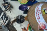 Sejumlah siswa melakukan aksi simpatik membakar ikan bandeng di kantor Perikanan Sidoarjo, Jawa timur, Rabu (6/4). Aksi tersebut untuk memperingati hari Nelayan Nasional dan bentuk ajakan gemar makan dan beli ikan hasil nelayan. Antara Jatim/Umarul Faruq/zk/16