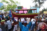 Sejumlah nelayan tradisional Sumut membawa miniatur kapal yang menggunakan alat tangkap pukat Grandong dan Trawl saat melakukan aksi unjukrasa di depan kantor Gubernur Sumatera Utara, Medan, Kamis (14/4). Mereka menuntut pemerintah untuk menindak pelaku yang masih menggunakannya pukat Grandong dan Trawl disekitar wilayah perairan Sumatera Utara karena dianggap merusak lingkungan dan merugikan para nelayan. ANTARA SUMUT/Septianda Perdana/16