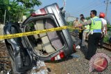 Petugas memasang police line di lokasi tabrakan kereta api Doho jurusan Blitar - Surabaya di perlintasan Kereta Api (KA) tanpa perlintasan desa Gilang, Taman, Sidoarjo, Jawa Timur, Kamis (14/4). Kecelakaan yang melibatkan mobil Toyota Kijang Inova nopol L.1649.RK dan terseret sepanjang 1 Km tersebut mengakibatkan empat orang meninggal dan dua orang mengalami luka serius. Antara Jatim/Umarul Faruq/zk/16