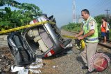 Petugas memasang police line di lokasi tabrakan kereta api Doho jurusan Blitar - Surabaya di perlintasan Kereta Api (KA) tanpa perlintasan desa Gilang, Taman, Sidoarjo, Jawa Timur, Kamis (14/4). Kecelakaan yang melibatkan mobil Toyota Kijang Inova nopol L.1649.RK dan terseret sepanjang 1 Km tersebut mengakibatkan empat orang meninggal dan dua orang mengalami luka serius. Antara Jatim/Umarul Faruq/zk/16