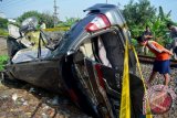 Warga menyaksikan mobil yang tertabrak kereta api (KA) Doho jurusan Blitar - Surabaya di perlintasan Kereta Api (KA) tanpa perlintasan desa Gilang, Taman, Sidoarjo, Jawa Timur, Kamis (14/4). Kecelakaan yang melibatkan mobil Toyota Kijang Inova nopol L.1649.RK dan terseret sepanjang 1 Km tersebut mengakibatkan empat orang meninggal dan dua orang mengalami luka serius. Antara Jatim/Umarul Faruq/zk/16
