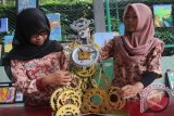 Pelajar melihat jam dinding dari limbah logam yang dipajang dalam pameran Karya Dari Sampah di halaman SMK 6, Malang, Jawa Timur, Kamis (14/4). Pameran hasil karya pelajar tersebut merupakan upaya mendorong kreatifitas pelajar dalam pemanfaatan sampah terkait ancaman perubahan iklim. Antara Jatim/Ari Bowo Sucipto/zk/16.