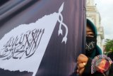 Massa Hizbut Tahrir Indonesia melakukan aksi jalan keliling kota sambil membawa bendera, spanduk dan poster di Banda Aceh, Aceh, Jumat (15/4). Aksi tersebut untuk mengajak umat Islam menjalankan syariat dengan kaffah dan saling menjaga serta saling menghormati sesama muslim maupun non muslim. ANTARA FOTO/Irwansyah Putra/foc/16.