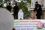 Algojo melaksanakan hukuman cambuk terhadap terhukum dalam kasus khalwat di Masjid Jantho, Kabupaten Aceh Besar, Provinsi Aceh, Jumat (15/4). Mahkamah Syariat Islam di daerah itu menjatuhkan vonis hukuman cambuk terhadap sebanyak 21 orang pelaku judi dan khalwat, masing-masing mendapat hukuman 7 hingga 12 kali cambuk di hadapan umum. ANTARA FOTO/Ampelsa/foc/16.
