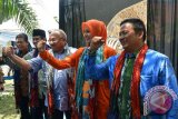 Wakil Ketua Komisi VI DPR RI Azam Azman Natawijana (tengah), Bupati Jember Faida (kedua kanan), Bupati Bondowoso Amin Said Husni (kedua kiri), Direktur Keuangan dan Operasi PT Permodalan Nasional Madani Kemas Hasani (kiri) mengepalkan tangan di Gallery Batik Tulis Sumbersari, Maesan, Bondowoso, Jawa Timur, Minggu (17/4). Workshop membatik merupakan kegiatan sinergi antara PT Permodalan Nasional Madani dengan pelaku Usaha Mikro Kecil Menengah (UMKM) di Bondowoso dan Jember untuk memperkuat produk mereka bersaing di era pasar bebas ASEAN atau Masyarakat Ekonomi ASEAN (MEA).
Antara Jatim/Seno/zk/16.