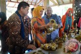 Wakil Ketua Komisi VI DPR RI Azam Azman Natawijana (kedua kanan), Bupati Jember Faida (kanan),  Direktur Keuangan dan Operasi PT Permodalan Nasional Madani Kemas Hasani (kiri) melihat produk kuningan di Gallery Batik Tulis Sumbersari, Maesan, Bondowoso, Jawa Timur, Minggu (17/4). Workshop membatik merupakan kegiatan sinergi antara PT Permodalan Nasional Madani dengan pelaku Usaha Mikro Kecil Menengah (UMKM) di Bondowoso dan Jember untuk memperkuat produk mereka bersaing di era pasar bebas ASEAN atau Masyarakat Ekonomi ASEAN (MEA).Antara Jatim/Seno/zk/16
