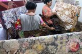 Sejumlah perajin menorehkan malam pada bahan kain yang telah diberi motif batik tertentu di sentra batik tradisional di Desa Majan, Tulungagung, Jawa Timur, Selasa (19/4). Batik tulis majan dengan motif khas gadjah mada yang memiliki ciri lima unsur warna dalam satu kain dijual dengan harga di kisaran Rp500 ribu hingga Rp750 ribu per lembar. Antara Jatim/Destyan Sujarwoko/zk/16