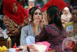 Pelajar memake-up wajah rekannya dalam lomba tata rias busana tradisional memperingati Hari Kartini di SMA Negeri 1 Kedungwaru, Tulungagung, Jawa Timur, Kamis (21/4). Kegiatan itu digelar untuk memperingati jasa pahlawan RA Kartini dalam mendorong emansipasi wanita sekaligus mengasah ketrampilan siswa di bidang seni tata rias wajah dan busana tradisional. Antara Jatim/Destyan Sujarwoko/zk/16