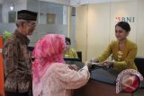 Karyawan melayani transaksi di kantor BNI, Malang, Jawa Timur, Kamis (21/4). PT Bank Negara Indonesia (BNI) mencatat pendapatan non bunga tumbuh 16 persen menjadi Rp2,21 triliun per Maret 2016 dibandingkan bulan Maret 2015 yang sebesar Rp1,90 triliun sementara target pendapatan berbasis biaya (fee based income) pada tahun 2016 naik hingga 30 persen dengan mengembangkan e-banking dan e-channel. Antara Jatim/Ari Bowo Sucipto/zk/16. 