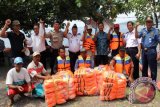 Kepala dinas Pariwisata Banyuwangi MY Bramuda (keempat kanan) bersama Kepala KSOP Agus Sularto (keempat kiri) dan perwakilan Anggota kepolisian perairan Banyuwangi foto bersama nahkoda kapal wisata setelah memberikan sosialisasi dan pemberian bantuan life jacket di Grand Watu Dodol, Banyuwangi, Jawa Timur, Kamis (21/4). Pemberian life jacket yang sesuai Standard Operasional Procedure (SOP)kepada pelaku kapal wisata tersebut, diharapkan dapat memberikan kepastian keselamatan bagi para pengunjung yang menyeberang ke Pulau Tabuhan, Menjangan atau sekedar berkeliling di Pantai Watu Dodol. Antara Jatim/ Budi Candra Setya/zk/16.