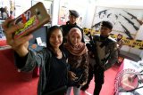 Pengunjung berfoto selfi didepan stand Blitar Polres Expo 2016 di Blitar, Jawa Timur, Jum'at (22/4). Pameran yang menampilkan berbagai jenis senjata, peralatan khusus (Alsus) serta peralatan utama (Alut) kepolisian tersebut di gelar oleh Polres Blitar dengan tujuan mengenalkan berbagai peralatan kerja serta untuk lebih mendekatkan lagi polisi dengan masyarakat. Antara Jatim/Irfan Anshori/zk/16