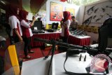 Pengunjung berfoto dengan senjata dalam Blitar Polres Expo 2016 di Blitar, Jawa Timur, Jum'at (22/4). Pameran yang menampilkan berbagai jenis senjata, peralatan khusus (Alsus) serta peralatan utama (Alut) kepolisian tersebut di gelar oleh Polres Blitar dengan tujuan mengenalkan berbagai peralatan kerja serta untuk lebih mendekatkan lagi polisi dengan masyarakat. Antara Jatim/Irfan Anshori/zk/16