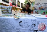 Komikus muda Dodi Pratama yang tergabung dalam komunitas Komik Digidoy Medan menampilkan hasil karyanya di Medan, Sumatera Utara, Jumat (22/4). Tren komik konteks lokal kini banyak digandrungi oleh masyarakat yang menampilkan berbagai cerita kehidupan dan pesan moral lewat komik. ANTARA SUMUT/Septianda Perdana/16