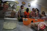 Sejumlah petugas dari Ditreskrimsus Polda Jatim menggelar barang bukti dan tersangka saat rilis pengungkapan kasus illegal fishing di Surabaya, Jawa Timur, Jumat (22/4).Polda Jatim mengamankan tersangka berinisial SW  dan barang bukti berupa 100 ekor benih lobster yang sudah diawetkan dan 4.700 benih lobster yang diserahkan ke Balai Karantina untuk dilepaskan serta 11 resi bukti pengiriman. Antara Jatim/Moch Asim/zk/16