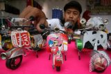 Perajin menyelesaikan pembuatan miniatur motor Vespa berbahan baku utama dari kaleng bekas minuman ringan di Kelurahan Blabak, Kota Kediri, Jawa Timur, Sabtu (23/4). Kerajinan tangan seharga Rp35.000 - Rp100.000 per buah yang memanfaatkan sejumlah limbah tersebut banyak diburu oleh kolektor dari Jakarta dan Surabaya. Antara Jatim/Prasetia Fauzani/zk/16