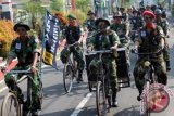 Sejumlah peserta parade berkostum pejuang mengendarai sepeda kuno di salah satu jalan protokol di Kota Blitar, Jawa Timur, Minggu (24/4). Parade sepeda kuno bertajuk 'Temu Onthel' yang diikuti sekitar 3.560 pecinta sepeda kuno dari berbagai daerah di indonesia tersebut digelar untuk mengampanyekan rasa nasionalisme melalui pengenalan sejarah dan budaya Indonesia melalui sepeda. ANTARA FOTO/Irfan Anshori/wdy/16