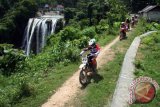Sejumlah pengendara trail menyusuri jalan setapak di dekat air terjun Nglirip, di Desa Mulyoagung, Kecamatan Singgahan, Tuban, Jawa Timur, Minggu (24/4). Sedikitnya 1.000 pengendara trail dari berbagai daerah di Jawa Timur, Jawa Tengah, juga luar Jawa, mengikuti ajang Tuban 