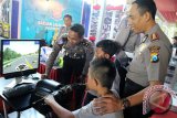 Kapolres Blitar AKBP Slamet Waloya (Kanan) mendampingi anak-anak bermain simulator kendaraan roda dua dalam penutupan Blitar Police Expo 2016 di Blitar, Jawa Timur, Minggu (24/4). Selain untuk mengenalkan berbagai peralatan khusus dan peralatan utama kepolisian, pameran yang digelar selama tiga hari tersebut juga bertujuan untuk mengkampanyekan gerakan nasional polisi sahabat anak. Antara Jatim/Irfan Anshori/zk/16