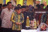 Wakil Presiden RI, Jusuf Kalla (kedua kiri) bersama Gubernur DIY, Sri Sultan HBX (kiri) mengamati berbagai penghargaan yang diperoleh Kabupaten Kulonprogon saat acara Peringatan Hari Otonomi Daerah ke-20 bertajuk 'Memantapkan Otonomi Daerah Menghadapi Tantangan Masyarakat Ekonomi Asean' di Kulonprogo, DI Yogyakarta, Senin (25/4). Dalam acara tersebut sebanyak tiga provinsi, 10 kabupaten, dan 10 kota mendapatkan penghargaan Satyalencana Karyabhakti Praja Nugraha karena bersatus kinerja terbaik berdasarkan hasil evaluasi kinerja penyelenggaraan pemerintahan daerah. ANTARA FOTO/Andreas Fitri Atmoko/wdy/16.