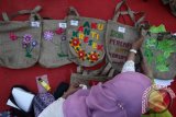 Para ibu menghias tas kain di Surabaya, Jawa Timur, Minggu (24/4). Kegiatan dengan tema Wanita Surabaya Tanpa Tas Plastik yang diikuti ratusan ibu-ibu tersebut untuk mengajak masyarakat agar tidak lagi menggunakan tas dari bahan plastik dan beralih menggunakan tas yang ramah lingkungan. Antara Jatim/Didik Suhartono/zk/16