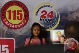 Seorang anak pengunjung pameran berpose dengan latar belakang nomor emergency call center 115 Basarnas, Kolaka, Sulawesi Tenggara, Senin (25/4/2016). Badan SAR Nasional terus mensosialisasikan nomor telepon darurat 115 yang bisa dihubungi masyarakat jika membutuhkan bantuan tim Basanas di daerah-daerah se-Indonesia. (ANTARA FOTO/Jojon)