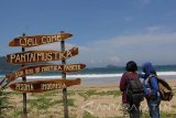 Dua orang wisatawan menikmati keindahan Pantai Mustika, Pancer, Banyuwangi, Jawa Timur, Rabu (27/4). Pantai mustika yang berada di selatan Kabupaten Banyuwangi tersebut, merupakan tempat wisata baru yang menawarkan keindahan pasir putih yang masih alami, Selain itu juga menjadi tempat trasit wisatawan yang akan melanjutkan ke pantai Wedi Ireng dan Teluk ijo menggunakan perahu nelayan. Antara Jatim/ Budi Candra Setya/zk/16.