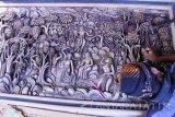 Perajin memahat lukisan tiga dimensi (relief) pada bidang kayu jati di sebuah rumah seni ukir kayu di Tulungagung, Jawa Timur, Kamis (28/4).  Produk seni lukis tiga dimensi berbentuk relief dijual antara Rp5 juta hingga Rp15 juta per buah sesuai ukuran dan tingkat kerumitan pembuatan, dengan segmen pasar pecinta seni ukir dalam negeri maupun mancanegara. Antara Jatim/Destyan Sujarwoko/zk/16