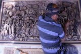 Perajin memahat lukisan tiga dimensi (relief) pada bidang kayu jati di sebuah rumah seni ukir kayu di Tulungagung, Jawa Timur, Kamis (28/4).  Produk seni lukis tiga dimensi berbentuk relief dijual antara Rp5 juta hingga Rp15 juta per buah sesuai ukuran dan tingkat kerumitan pembuatan, dengan segmen pasar pecinta seni ukir dalam negeri maupun mancanegara. Antara Jatim/Destyan Sujarwoko/zk/16