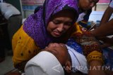 Seorang ibu berusaha menenangkan anaknya ketika berlangsungnya proses sunatan massal di aula Bharadaksa Polres Sidoarjo, Jawa Timur, Jumat (29/4). Kegiatan tersebut merupakan bakti sosial dalam rangka wujud kepedulian Polri kepada para buruh di Sidoarjo jelang perayaan hari buruh se-Dunia 1 Mei mendatang. Antara Jatim/Umarul Faruq/zk/16